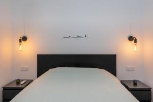 una camera da letto con un grande letto con due comodini di Tropical Lodge a Maspalomas