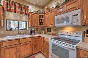 a kitchen with wooden cabinets and white appliances at Vibrant Home with Patio about 60 Miles to Grand Canyon! in Williams