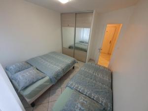 a small bedroom with two beds and a mirror at Apart 5 personnes, 1min Gare d'Annemasse, Genève 5km in Annemasse