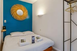 um quarto com uma cama com uma parede azul em Modern flat 50m from the Capitole - Toulouse - Welkeys em Toulouse
