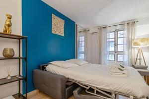 um quarto com 2 camas e uma parede azul em Modern flat 50m from the Capitole - Toulouse - Welkeys em Toulouse