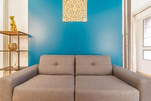 um sofá numa sala de estar com uma parede azul em Modern flat 50m from the Capitole - Toulouse - Welkeys em Toulouse