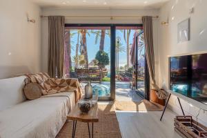 a living room with a couch and a large window at PHARUS retro beach home New Heated Pool in Maspalomas