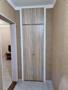 um armário com portas de madeira num quarto em Квартира 1-кімнатна в центрі Миргорода. em Myrhorod