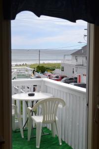 a balcony with a table and chairs and a view of the beach at The New Oceanic Inn in Old Orchard Beach