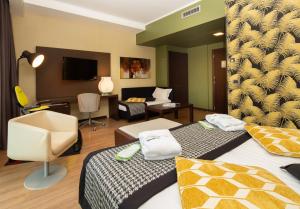 a hotel room with two beds and a living room at Holiday Inn Turin Corso Francia, an IHG Hotel in Turin