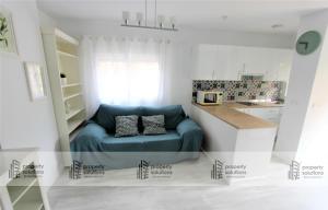 a living room with a blue couch in a kitchen at N135 - Apartamento Benalmádena - PISCINA - Playa a 300 metros in Benalmádena