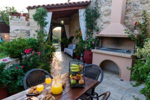 - une table avec des fruits sur une terrasse avec une cheminée dans l'établissement Armonia Villa, Unsurpassed privacy at picturesque location, By ThinkVilla, à Pasalítai