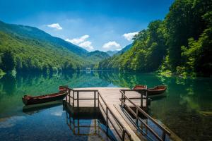 a dock on a lake with two boats on it at MM Kolasin Lux N1 in Kolašin