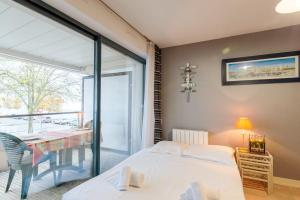 - une chambre avec un lit, une table et un balcon dans l'établissement Appartement Passereaux - Welkeys, à La Rochelle