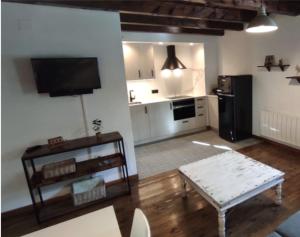 a living room with a couch and a table and a kitchen at Apartamento Linsoles Forcau in Benasque