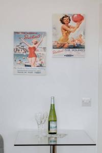 een tafel met een fles wijn en twee posters bij The Nook in Barnstaple