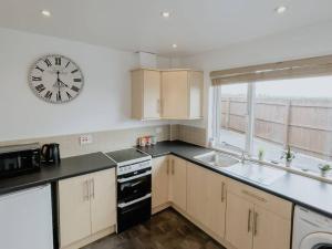 a kitchen with a clock on the wall and a sink at The Nook in Barnstaple +5 photos