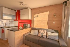 a living room with a couch and a kitchen at Cosy studio with balcony at the heart of L'Alpe d'Huez - Welkeys in LʼHuez