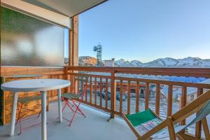 a balcony with a table and chairs and mountains at Cosy studio with balcony at the heart of L'Alpe d'Huez - Welkeys in LʼHuez
