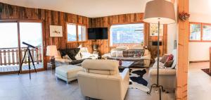 ein Wohnzimmer mit Holzvertäfelung und -möbeln sowie einem Balkon in der Unterkunft Chalet La Louve in Saint-Gervais-les-Bains