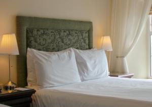 
a hotel room with a white bedspread and a white comforter at Walter Raleigh Hotel in Youghal
