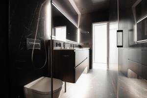 a bathroom with a toilet and a sink and a mirror at Cabo Noval Premium Suites, by Homing U in Seville
