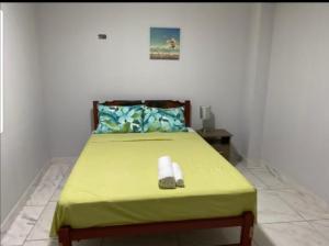 1 dormitorio con 1 cama con manta verde y reloj en Barranca Beach Apartments, en Barranca