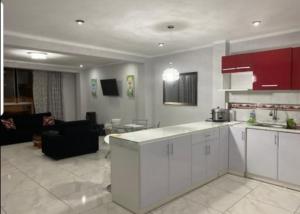 una cucina con armadi bianchi e un soggiorno di Barranca Beach Apartments a Barranca