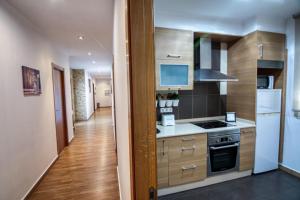 a kitchen with wooden cabinets and a white refrigerator at Night Day extra in Padrón