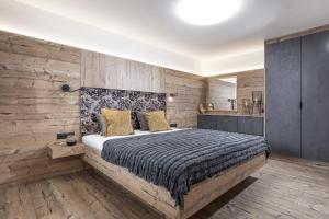 1 dormitorio con 1 cama y pared de madera en Apartment Katharina, en Brandberg