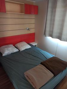 een slaapkamer met een bed met 2 kussens erop bij camping le novela in Port-la-Nouvelle