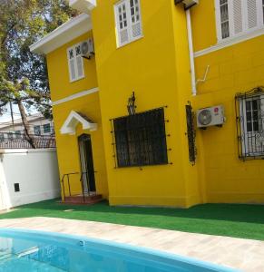 una casa amarilla con una piscina frente a ella en Arena Maracanã Hostel en Río de Janeiro