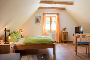 a attic bedroom with a bed and a window at heurigengasthof prinz in Krumau am Kamp