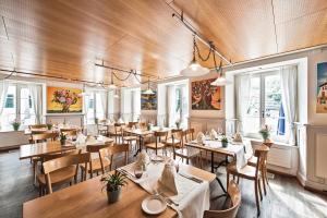 un restaurante con techos de madera, mesas y sillas en Hotel zum Hirschen, en Schindellegi
