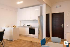a kitchen with white cabinets and a stainless steel refrigerator at Apartman Anđela in Kupres
