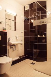 Łazienka z toaletą i szklanymi drzwiami prysznicowymi w obiekcie Hotel Era w Świeradowie Zdroju