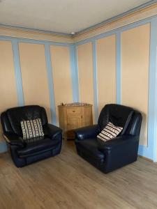 two black leather chairs sitting in a room at Casa Mia Fiemme in Carano