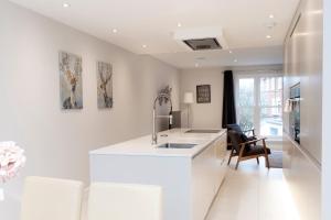 a white kitchen with a sink and a counter at Stunning Central Windsor Town House With Parking in Windsor