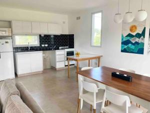 a kitchen and living room with a table and a couch at Casa con pileta y parrilla en barrio privado, 2 dormitorios in General Roca