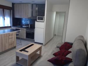 sala de estar con sofá y cocina en Piso amplio y reformado para grupos en Felechosa