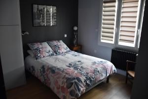 sypialnia z łóżkiem z kołdrą kwiatową w obiekcie Le Planard w mieście Rodez