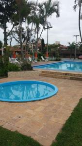 a large swimming pool with a blue pool at Chalé em Condomínio com piscina - Ponta das Canas in Florianópolis