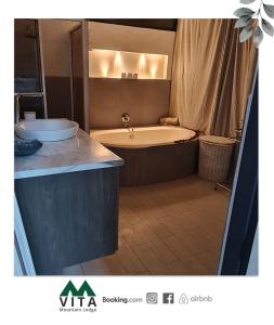 baño grande con bañera y lavamanos en Vita Mountain Lodge en Santa Lucía