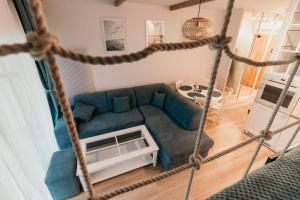 a living room with a blue couch and a table at Apartament Dar Pomorza 20m do Plaży Ustronie Apartments in Ustronie Morskie