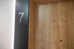 a door with the number seven on the side of it at Apartament Dar Pomorza 20m do Plaży Ustronie Apartments in Ustronie Morskie