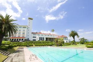 a swimming pool in front of a building at Kawana Hotel in Ito