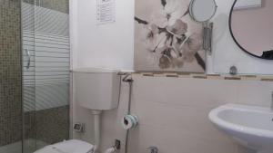 a bathroom with a toilet and a sink and a mirror at CconfortHotels Dolci Notti in Bari