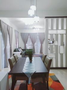 a dining room with a table and a living room at Sofea guest house kemaman in Cukai