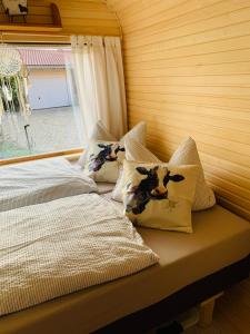 ein Schlafzimmer mit einem Bett mit Kissen und einem Fenster in der Unterkunft Irenes Tinyhouse in Markt Nordheim
