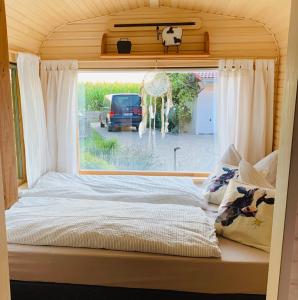 ein Bett in einem winzigen Haus mit Fenster in der Unterkunft Irenes Tinyhouse in Markt Nordheim