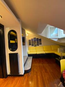 ein Wohnzimmer mit einer gelben Couch in einem Zimmer in der Unterkunft Lecco Centro in Lecco