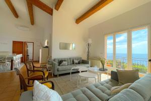 a living room with a couch and a table at Family villa with magnificent sea view for 11 people in Saint-Raphaël