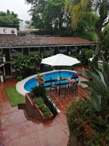 un patio con mesa, sombrilla y piscina en Casa Dalinda, en Valle de Bravo