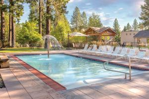 a swimming pool with white chairs and a fountain at Seventh Mountain in Bend